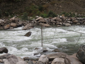 The river with a cable pully bridge. 